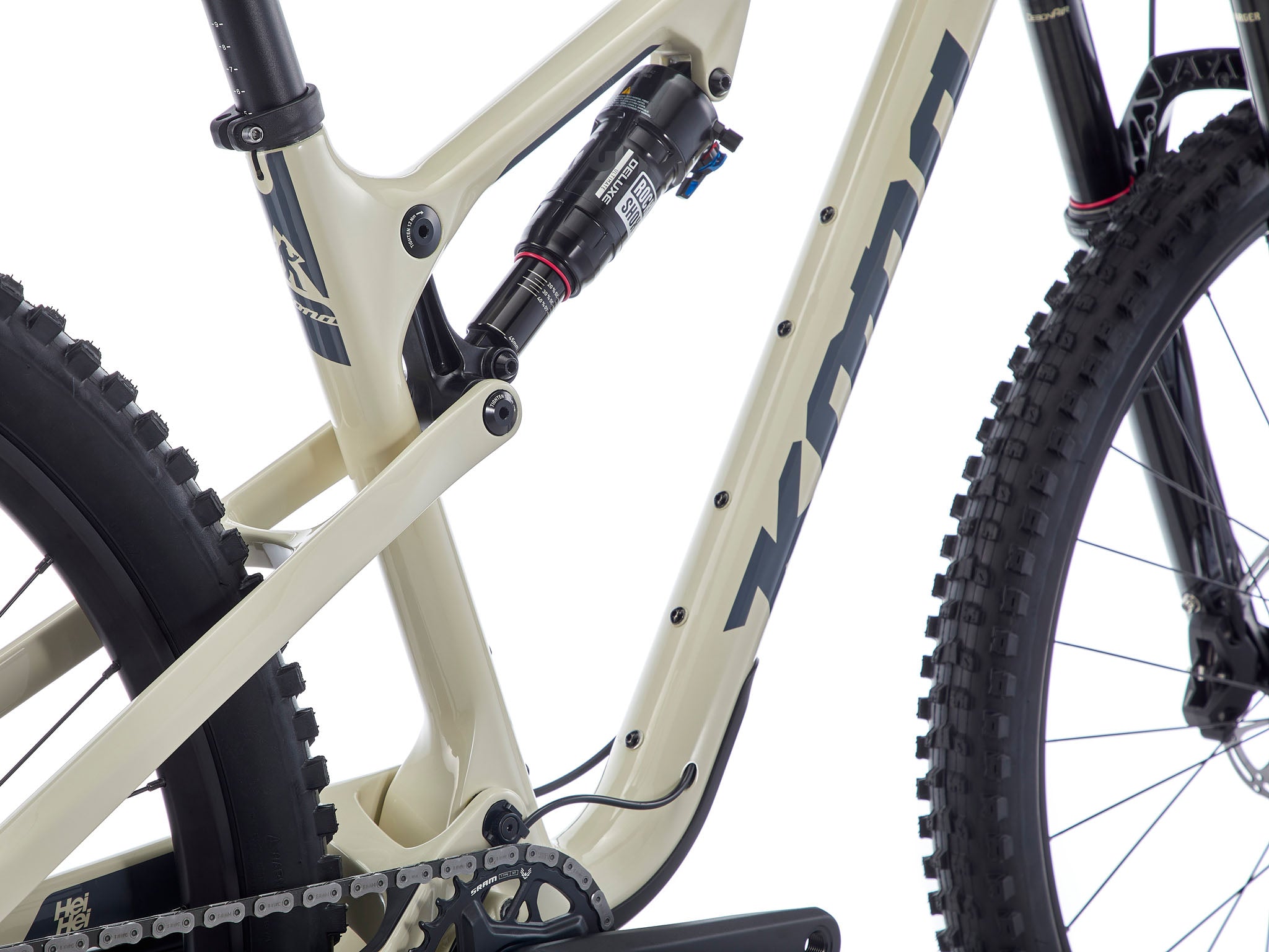 Side view of the Kona Hei Hei CR carbon mountain bike perched on a rocky ridge at sunrise, highlighting the sculpted carbon frame and 29-inch wheels ready for climbing.