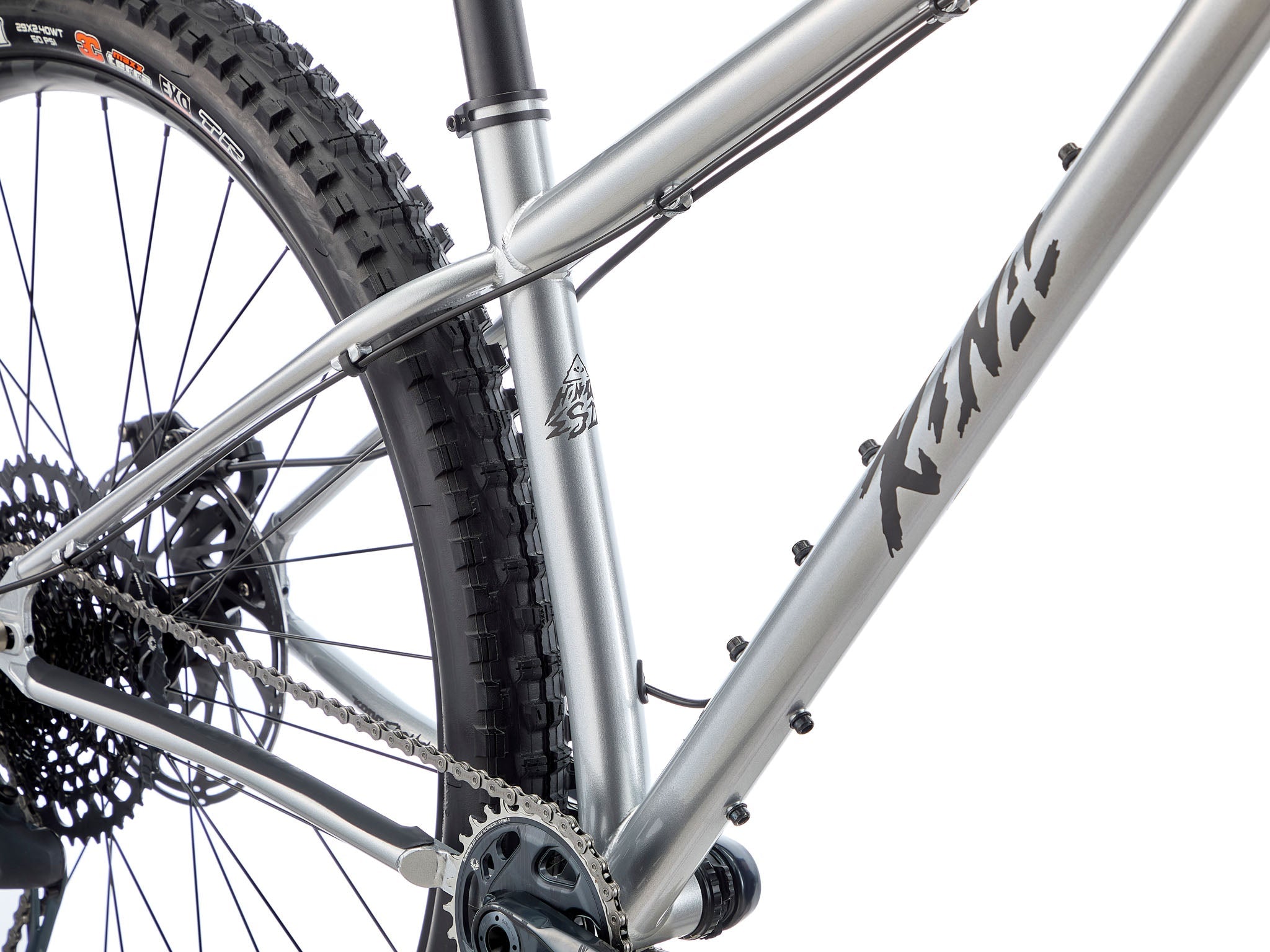 Honzo ESD leaned against a granite slab on an alpine ridge, sunset lighting the Maxxis tires and steel frame