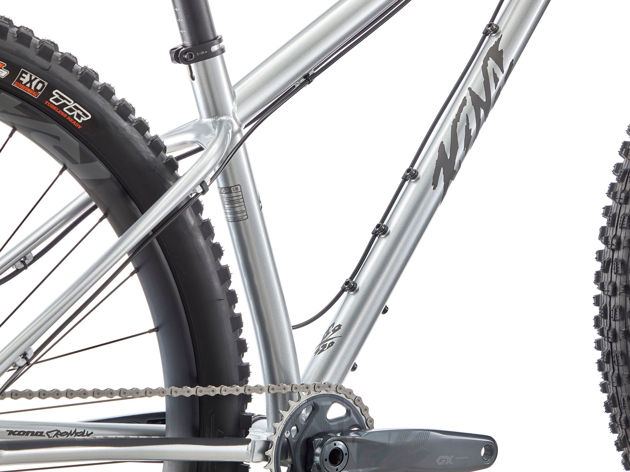 Kona Honzo ESD steel hardtail ripping down a root-laced trail, 150 mm fork fully compressed and rider pinned