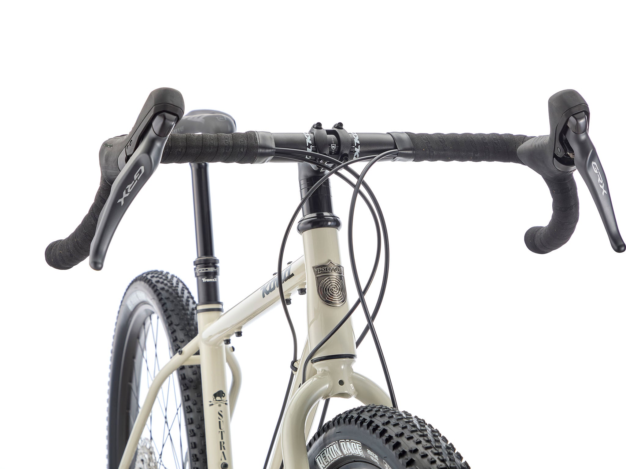 Close-up of flared drop bars and 2.1-inch knobby tires gripping a gravel climb