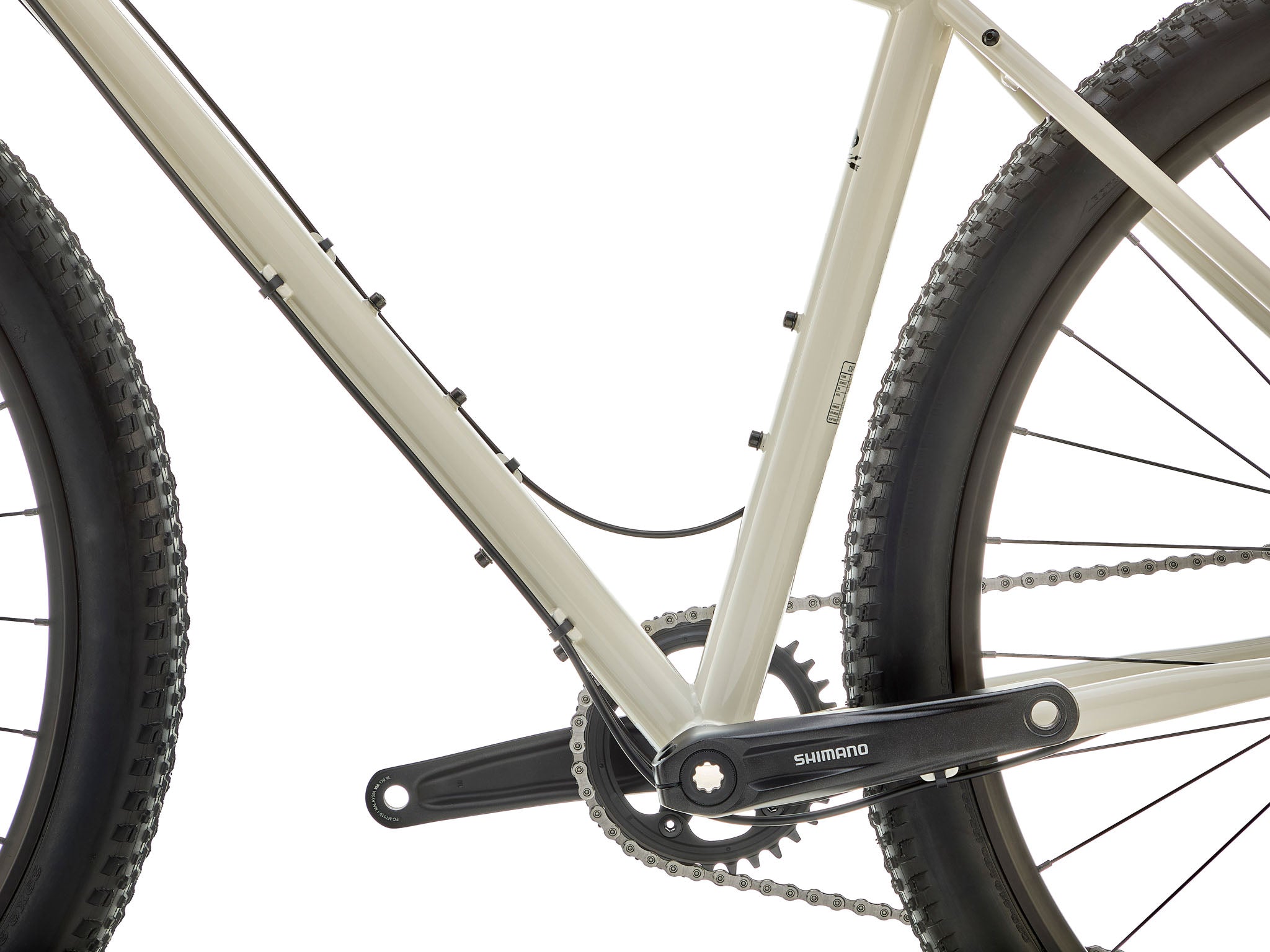 Close-up of flared drop bars and 2.1-inch knobby tires gripping a gravel climb