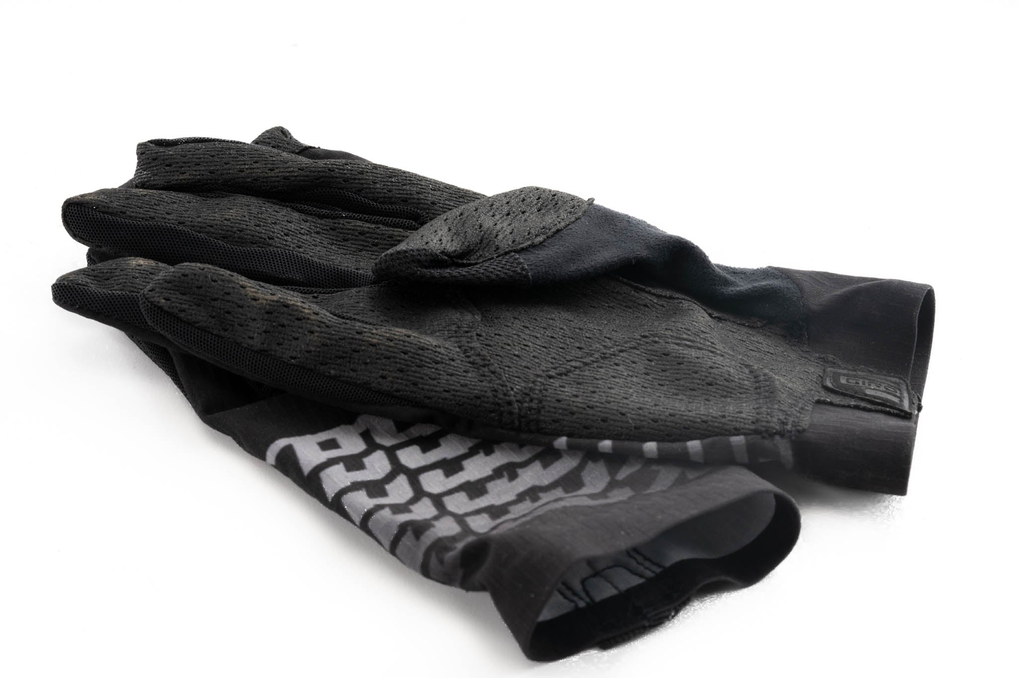 Action shot of a cyclist wearing Kona Nightfall gloves on rugged terrain, emphasizing performance.