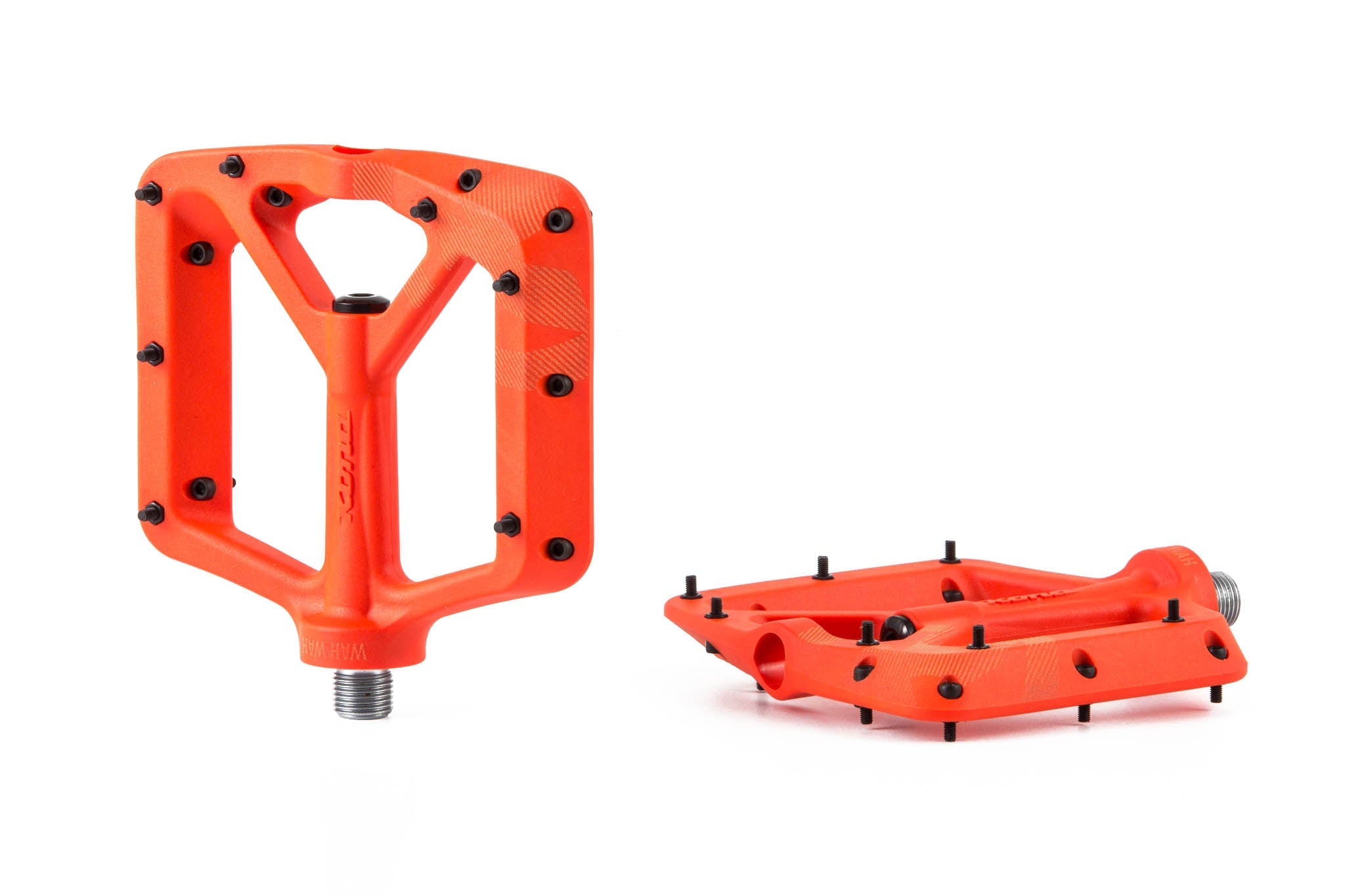 Side angle of durable flat pedals on mountain bike in rough terrain